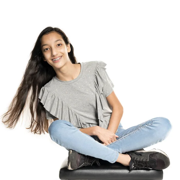 Brunetka dospívající dívka sedí na klavírní stolička — Stock fotografie