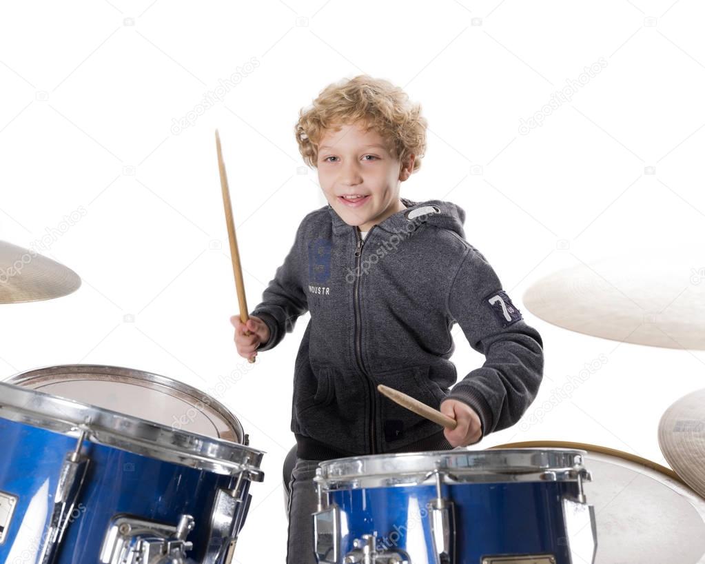 young blond caucasian boy at drumset in studio