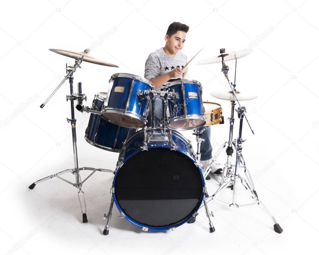 teen boy at drumset in studio against white background
