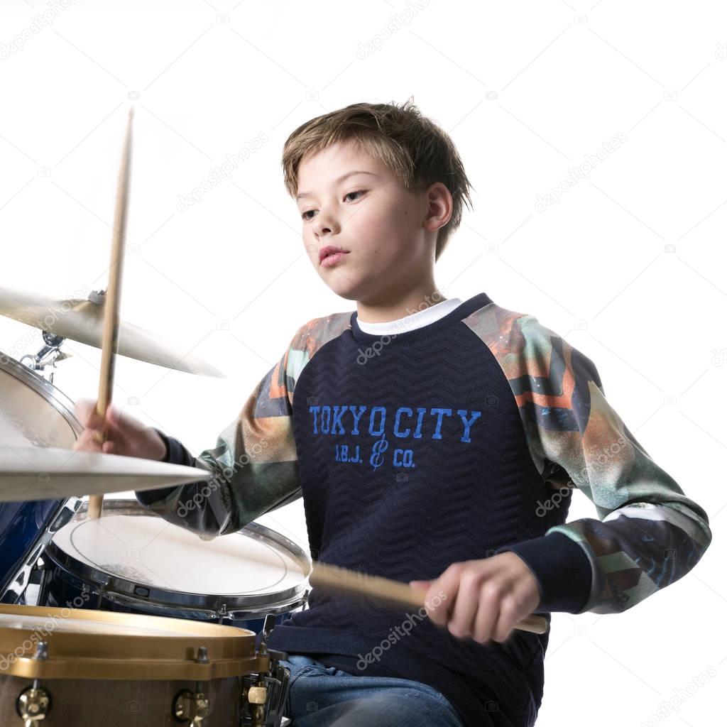 young blond boy at drum kit in studio