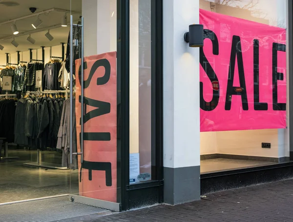 Das Wort Verkauf im Schaufenster des Bekleidungsgeschäfts — Stockfoto