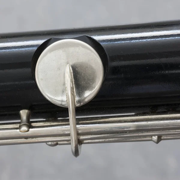 Close-up de parte do clarinete baixo com fundo cinza — Fotografia de Stock