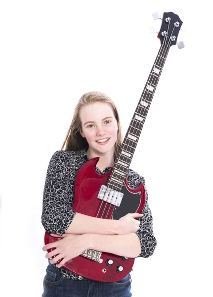Loira adolescente menina e baixo guitarra contra fundo branco em estúdio — Fotografia de Stock
