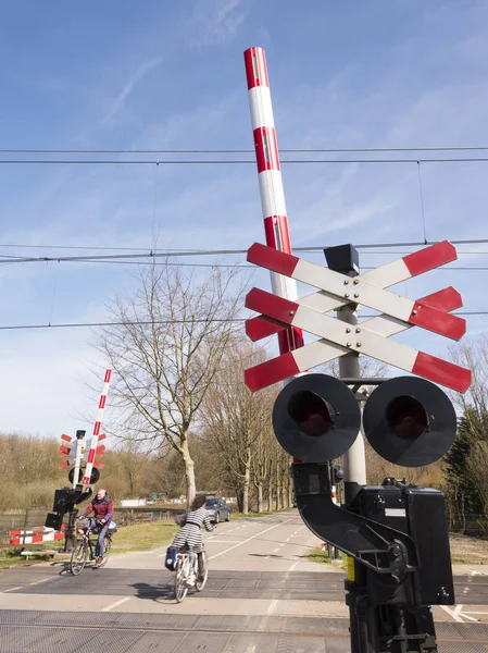 Przejazd kolejowy w Holandii z ludźmi, na rowerze, przechodzącą — Zdjęcie stockowe