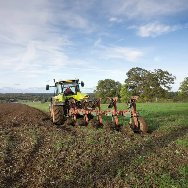 Traktor és eke a kék ég alatt a mező luxembourgh — Stock Fotó