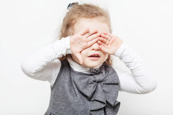 Маленькая кудрявая девочка закрыла глаза руками — стоковое фото