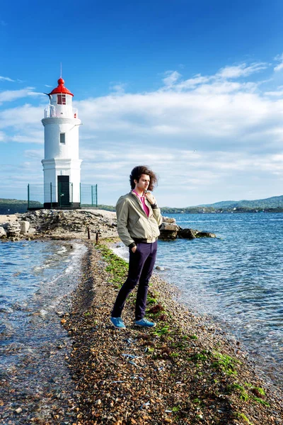 Beau jeune homme, phare dans la mer, beau paysage — Photo