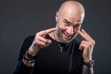 Gülümseyen acımasız kel adam