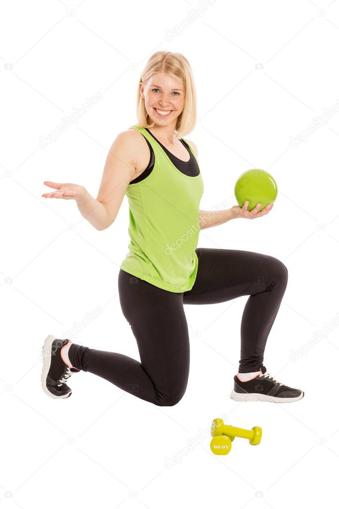 Beautiful young woman in bright sportswear with ball and dumbbel