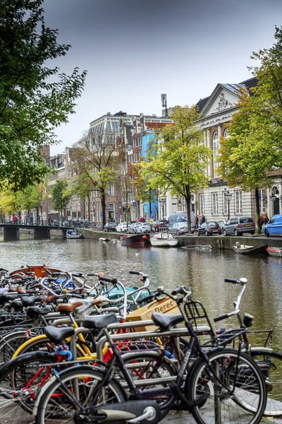 Ámsterdam, Países Bajos, 12 / 10 / 2019: Bicicletas aparcadas en un canal en el centro de la ciudad . — Foto de Stock