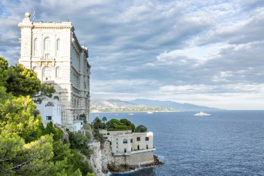 Deniz kenarındaki uçurumda güzel beyaz bir ev, güneşli bir gün. Metin için boşluk.