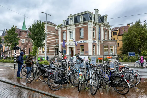 Amsterdam, Países Bajos, 12 / 10 / 2019: Aparcamiento para bicicletas en una ciudad con una hermosa arquitectura en un día lluvioso . — Foto de Stock
