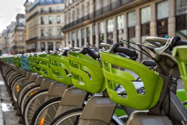 Otoparkta arka arkaya yeşil bagaj rafları olan şehir bisikletleri. Yakın plan..