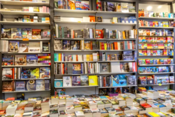 Ett stort utbud av böcker på hyllor i en bokhandel. Oklar. Bakgrund. Plats för text. — Stockfoto