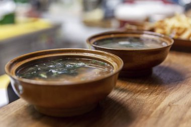 Masanın üzerinde sıcak Asya çorbası olan tabaklar. Yakın plan..