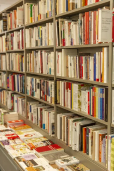 Regale mit Büchern in einer Reihe im Laden. Hintergrund verschwimmen lassen. — Stockfoto