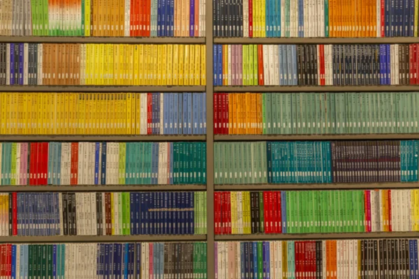 Regale mit Büchern in einer Reihe im Laden. Hintergrund verschwimmen lassen. — Stockfoto
