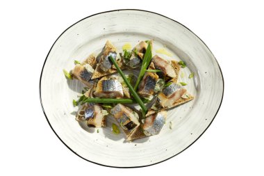 Tabağında yeşil soğan olan dilimler halinde iştah açıcı ringa. Üst Manzara. Beyaz arkaplan üzerinde izole edilmiş.