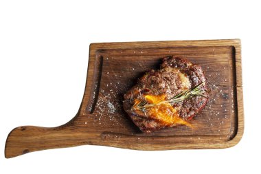 Tahta bir tahtanın üzerinde alevli dilli, iştah açıcı biftek. Üst Manzara. Beyaz arkaplan üzerinde izole edilmiş.