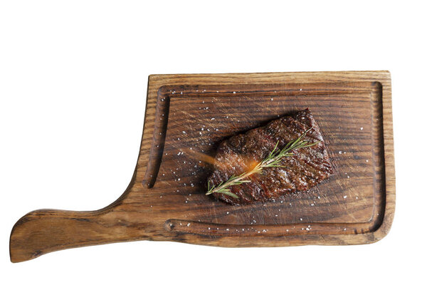 Appetizing meat steak with tongues of flame on a wooden board. top view. Isolated over white background.