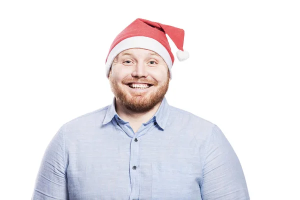 满脸笑容,红头发,留着胡子,身穿蓝色衬衫,头戴圣诞帽. 8.特写。 在白色背景下被隔离. — 图库照片