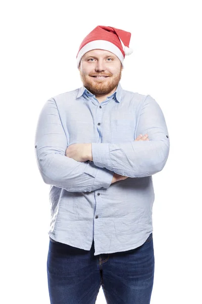 Посміхнений рудий чоловік з бородою в синій сорочці і в капелюсі Санта Клауса. Зблизька. Ізольовані на білому тлі. — стокове фото