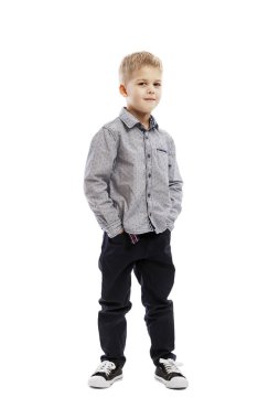 Standing serious preschool boy in a shirt and trousers. Isolated over white background.  clipart