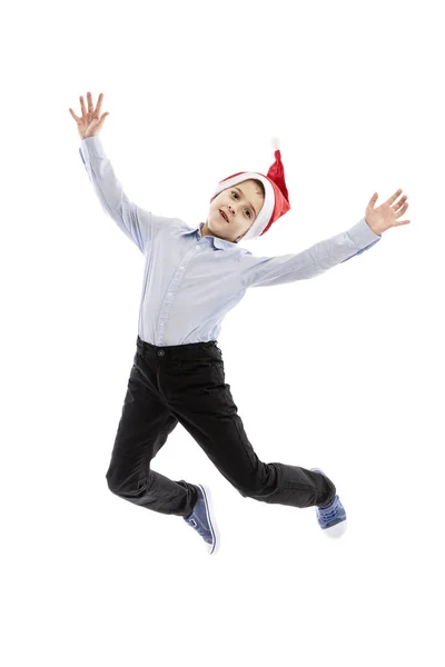 산타 모자를 쓰고 뛰어내리는 학생처럼 웃으면서 요. 전체 높이. 크리스마스 기분이야. 하얀 배경에 고립되어 있습니다. 수직. — 스톡 사진