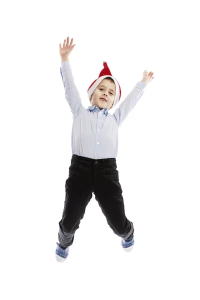 Écolier sautant souriant dans le chapeau du Père Noël. Pleine hauteur. L'humeur de Noël. Isolé sur fond blanc. Vertical . — Photo