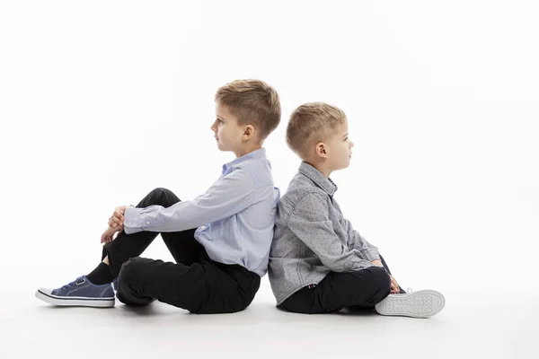 Twee leuke jongens zitten achterover op een witte achtergrond. Vriendschap en steun. — Stockfoto