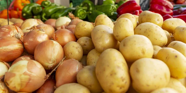 Potatis och lök på en marknadsdisk. Ett sortiment av produkter för vegetarianism. Närbild. Bakgrund. Plats för text. — Stockfoto