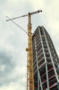 Güneşli bir günde mavi gökyüzüne karşı inşa halinde olan uzun modern bina.. 