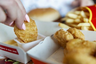Moskova, Rusya, 08 / 11 / 2019: Bir kadın McDonald 's' da Tavuk Külçeleri yiyor. Yakın plan..