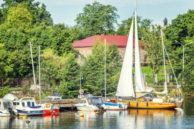 Yachts in a city marina on a river in Vyborg on a bright sunny day. Close-up. clipart