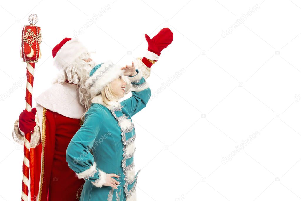 Russian Santa Claus with a snow maiden look into the distance. Isolated over white background. Space for text.