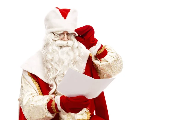 Santa Claus en gafas leyendo una carta de deseos con una lista de regalos. Primer plano. Aislado sobre un fondo blanco . — Foto de Stock