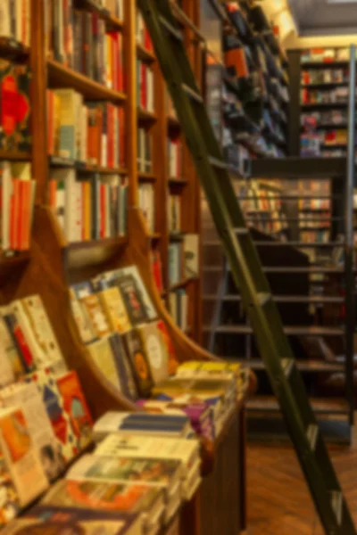 Regale mit dicht stehenden Büchern reihen sich in einem Geschäft aneinander. verschwommen. — Stockfoto