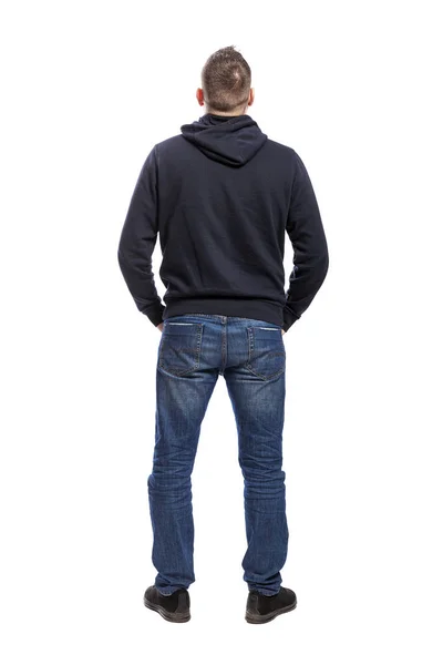 एक हुडी और जीन्स में एक युवा कैमरे पर अपनी पीठ के साथ खड़ा है। बैक व्यू। पूरी ऊंचाई। सफेद पृष्ठभूमि पर अलग . — स्टॉक फ़ोटो, इमेज