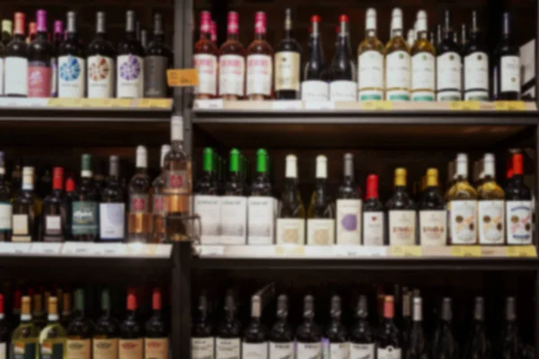 Una variedad de alcohol en el departamento de vinos de un supermercado. Borrosa. . — Foto de Stock