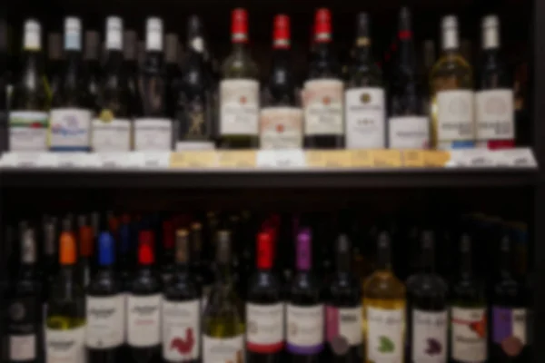 Un assortimento di alcolici nel reparto vino di un supermercato. Sfocato . — Foto Stock