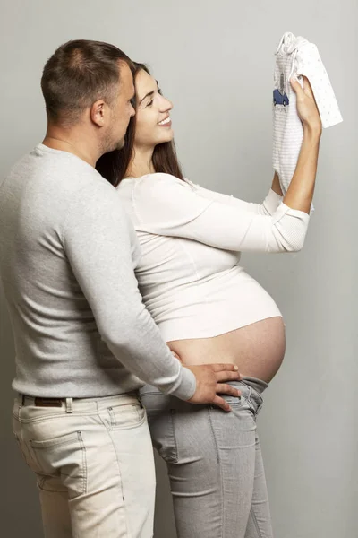 Een jong zwanger stel dat knuffelt en lacht. Wachten op geboorte en tedere relatie. — Stockfoto