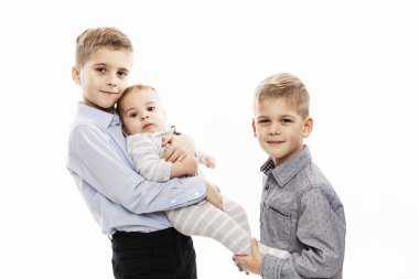 İki kardeş yeni doğmuş bir bebeği tutuyor. Aile içinde sevgi ve şefkat. Beyaz arkaplan.
