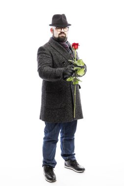 Zarif sakallı, şık bir ceket giymiş ve elinde kırmızı bir gül olan zarif bir adam. Tam yükseklik. Beyaz arkaplan üzerinde izole edilmiş. 