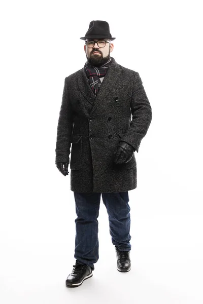 Uomo elegante con la barba in cappotto e cappello. Stand a tutta lunghezza su sfondo bianco . — Foto Stock