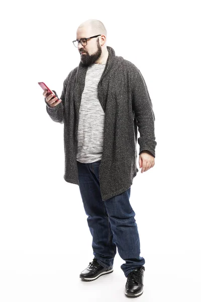 Hombre calvo en gafas con un teléfono en las manos. A toda altura. Aislado sobre fondo blanco . — Foto de Stock