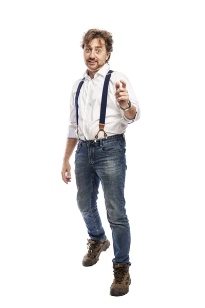 Un hombre sonriente con barba en camisa blanca y jeans señala hacia adelante con su dedo índice. A toda altura. Aislado sobre un fondo blanco . — Foto de Stock