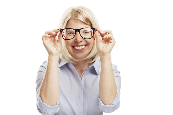Een jonge glimlachende vrouw met een stijlvolle bril en een blauw shirt zit aan tafel. Zakelijk succes. Geïsoleerd op een witte achtergrond. — Stockfoto