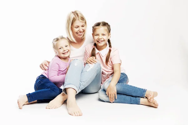 Junge Mutter mit kleinen Töchtern umarmen und lachen. Liebe und Zärtlichkeit. weißer Hintergrund. — Stockfoto