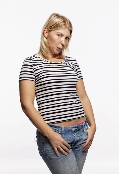Giovane donna bionda seria in jeans. Fondo bianco . — Foto Stock