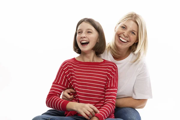 Молодая женщина со своей дочерью-подростком обнимается и смеется. Белый фон . — стоковое фото